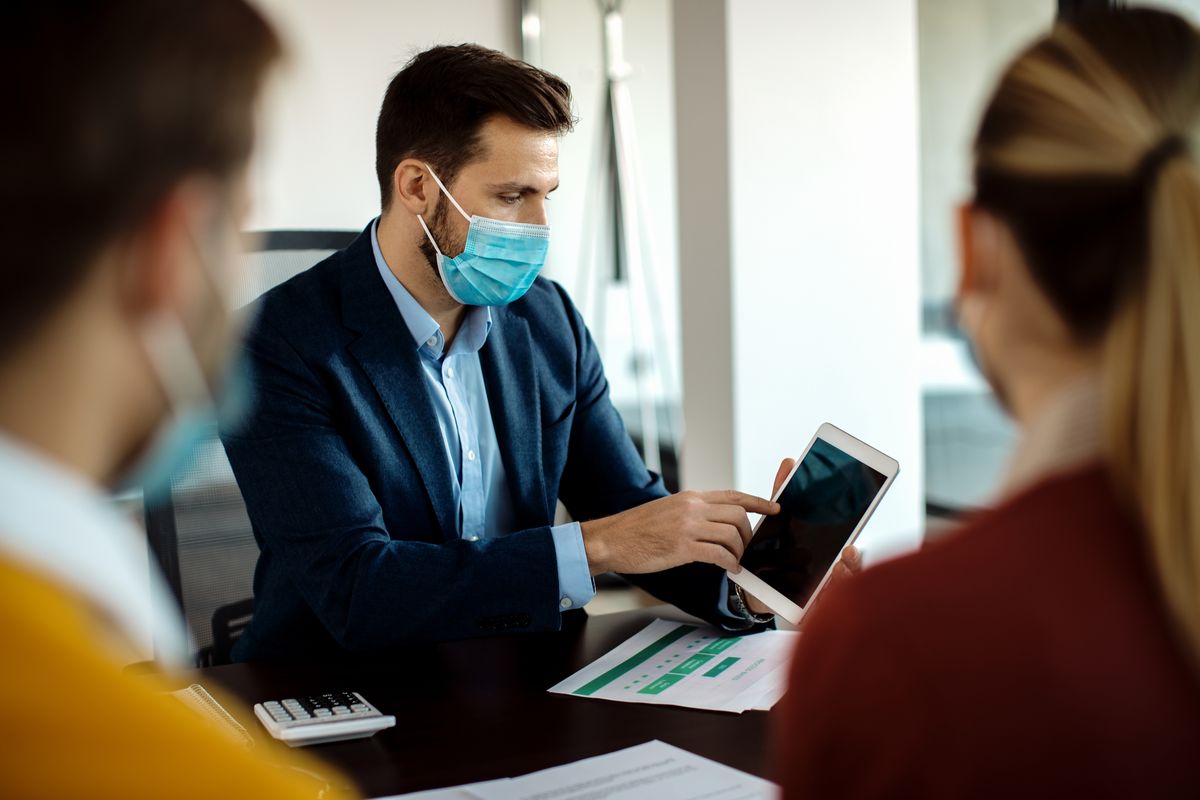 Specialist using a tablet in a meeting with clients